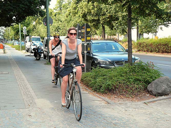 Zwei huebsche Radfahrerinnen eine ohne helm eine mit helm Kopie