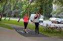 Huebsche Joggerin und huebsche Rollerskaterin nehmen den Radweg in Beschlag