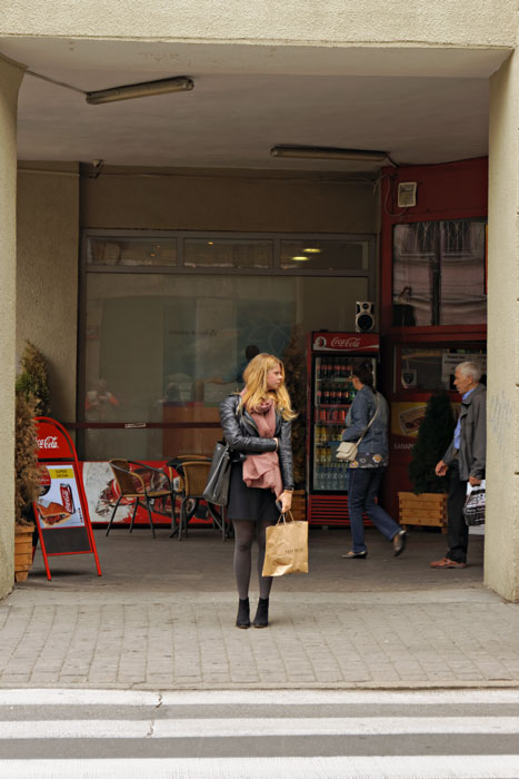 Huebsche-Girl-mit-mauve-Schal-schwarzer-Lederjacke-schwarzem-Rock-schwarzen-Strumpfhosen